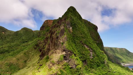 Aerial-orbiting-shot-of-green-mountains-on-Orchid-Island-during-cloudy-and-Sunny-day-in-Taiwan,-Asia