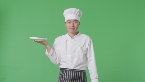 chef sosteniendo un plato frente a una pantalla verde