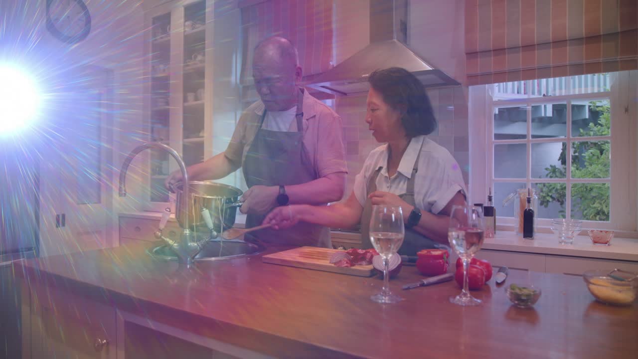 Man lifting pan toward sink while woman guiding pour to drain contents, cooking lens flare