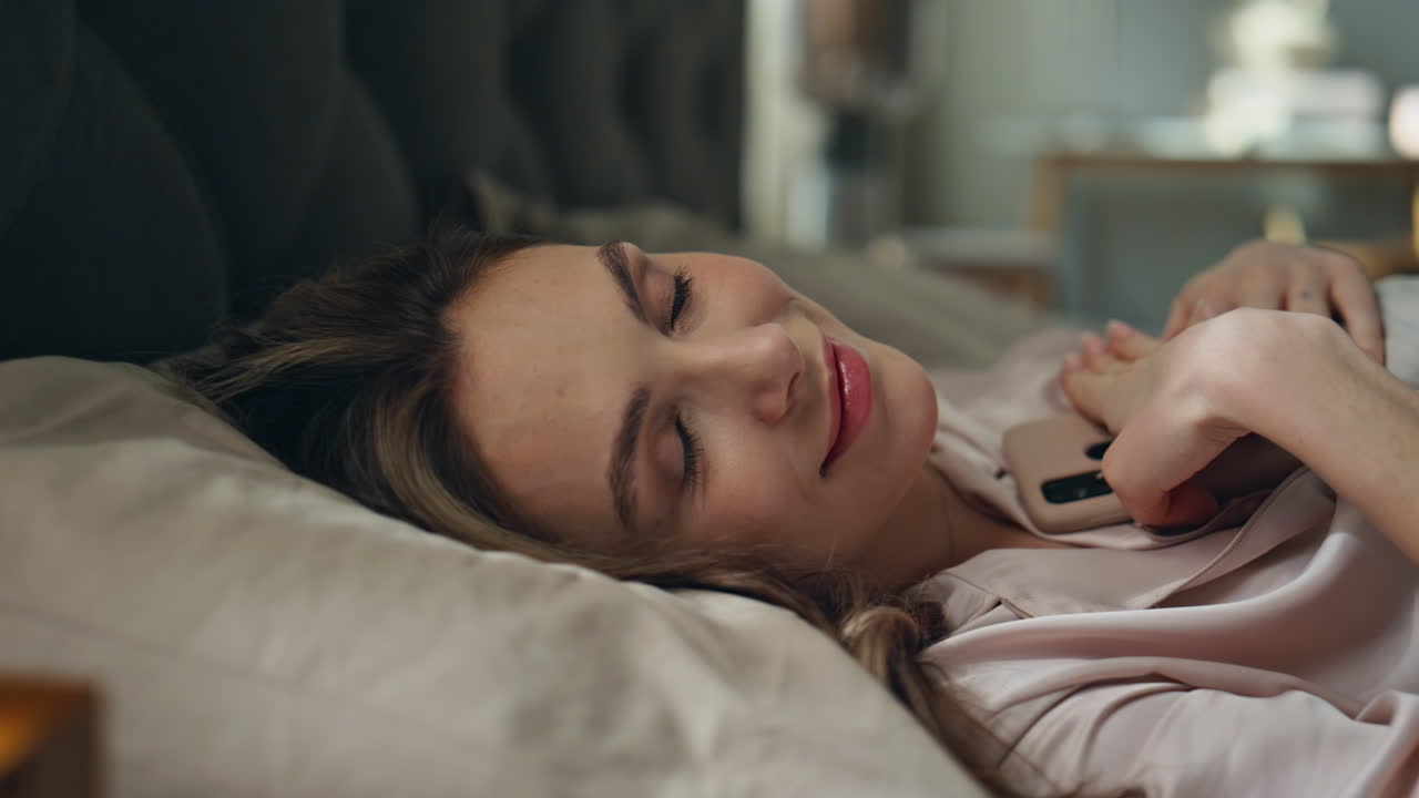 Woman sleeping in bed with phone