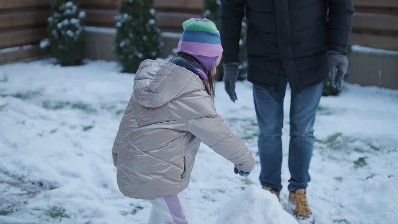 할아버지와 손녀가 눈 속에서 재미를 느끼고 있습니다.