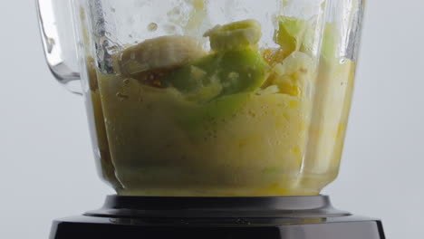 blender preparing fruit blend in super slow motion close up. healthy food.