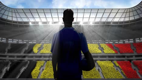 Animation-of-rear-view-of-football-player-holding-ball-over-belgian-flag-in-sports-stadium