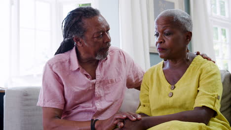 senior man comforting woman with depression at home