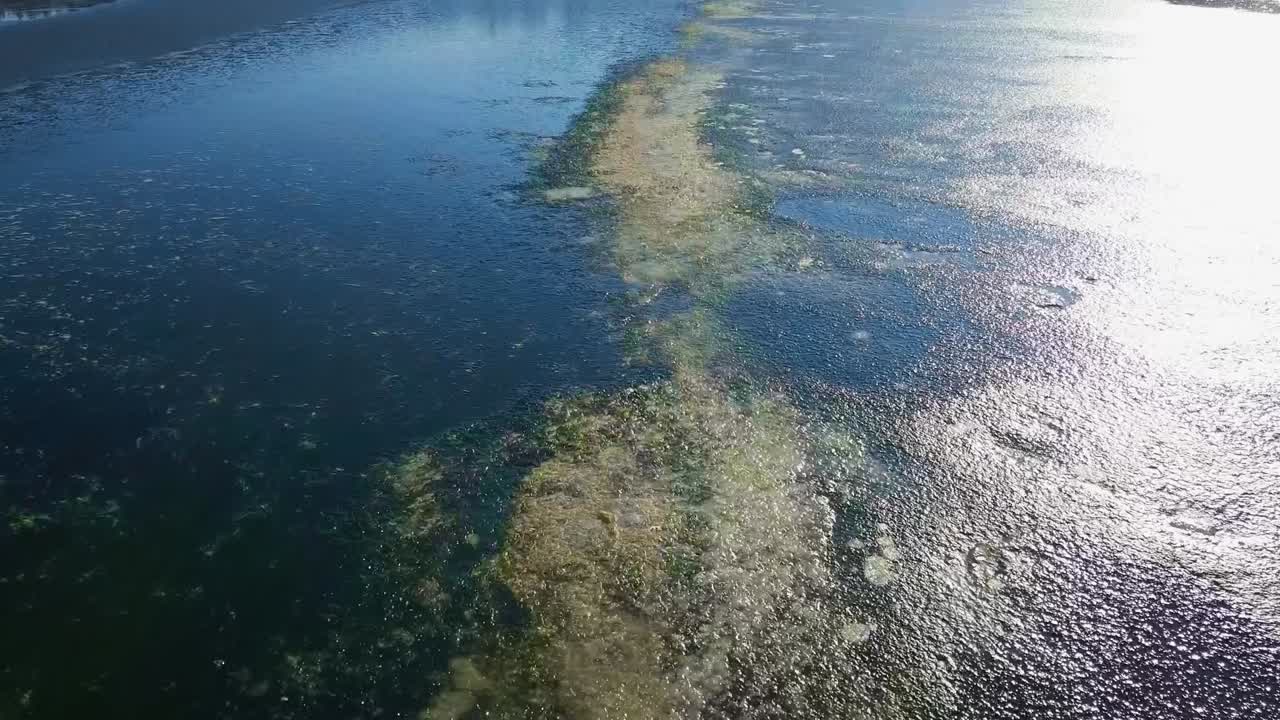 Scenic aerial flight just above frozen surface of Zovnek lake