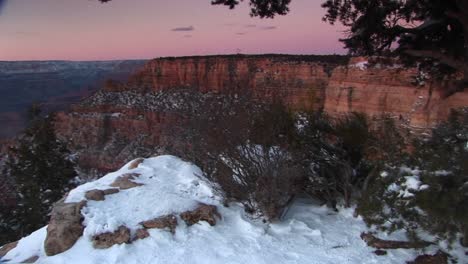 Weite-Aufnahme-Des-Grand-Canyon-National-Park-Mit-Vordergrund-Der-Klippen-Und-Schneebedeckten-Felsen,-Sträuchern-Und-Bäumen