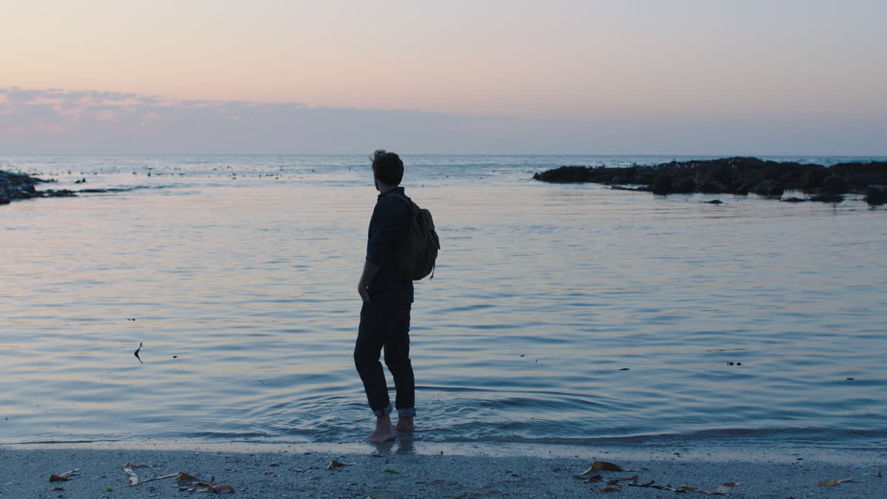 해가 지면 해변에서 걸어다니는 젊은 관광객의 초상화