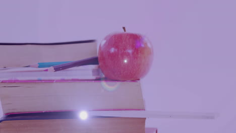 animación de luz brillante sobre la manzana en la pila de libros