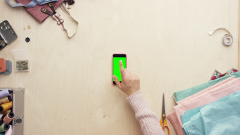 vista superior de las manos del diseñador de moda usando una aplicación de diseño de teléfono móvil trabajando en el escritorio desde arriba - dragón épico rojo