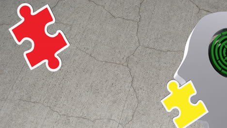 animation of green, yellow and red puzzle pieces falling over model of human head on grey background