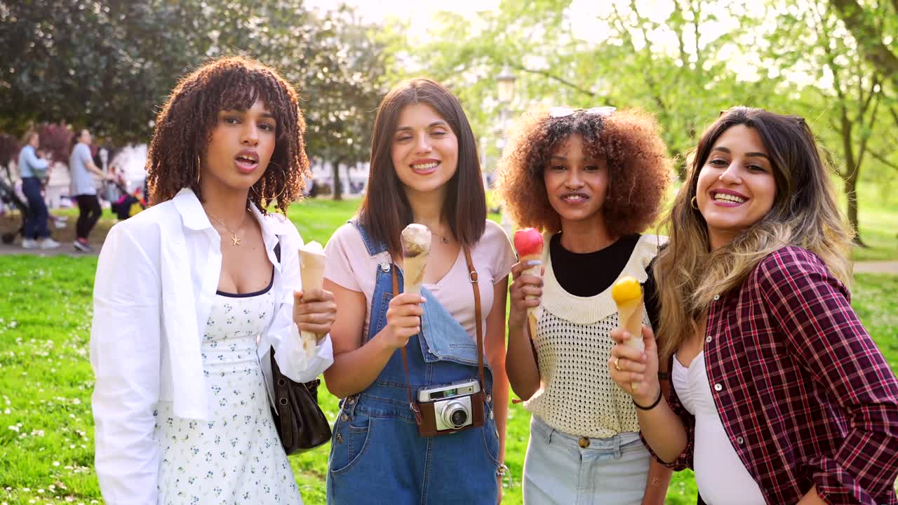Four friends enjoying ice cream in the park