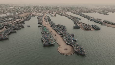 Vista-Aérea-De-Los-Barcos-De-Pesca-Amarrados-A-Lo-Largo-Del-Embarcadero-En-Ibrahim-Hyderi-En-Karachi