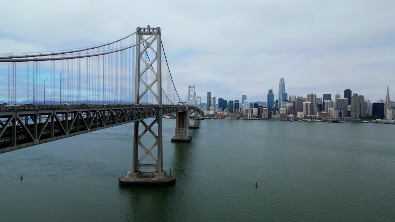 Drone flies forward over Oakland Bay Bridge toward San Francisco skyline (60fps)