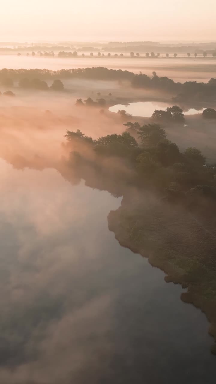 조용한 호수 위의 안개가 가득한 해가 뜨는 것