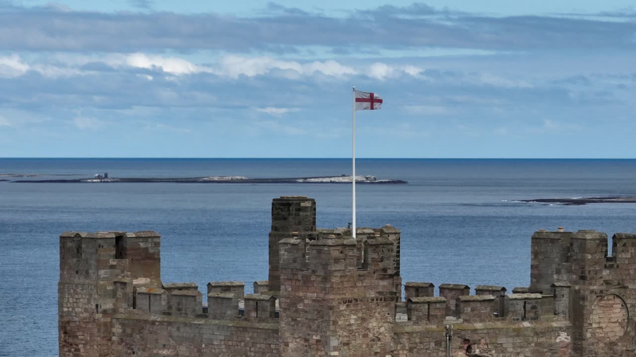 Flag of England flying in the wind at Bamburgh Castle
