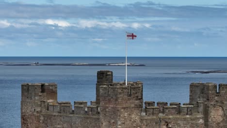 flag of england flying in the wind at bamburgh castle