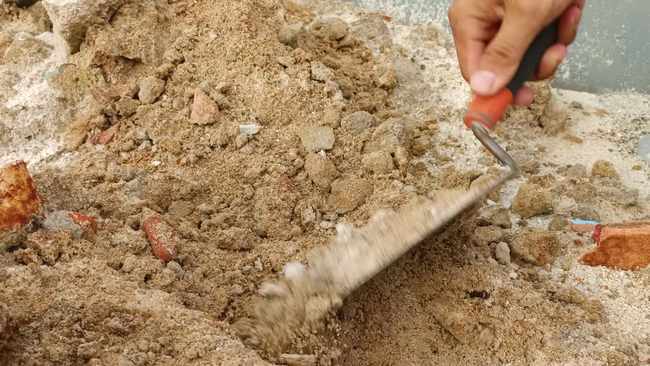 close up scooping up sand with a small shovel