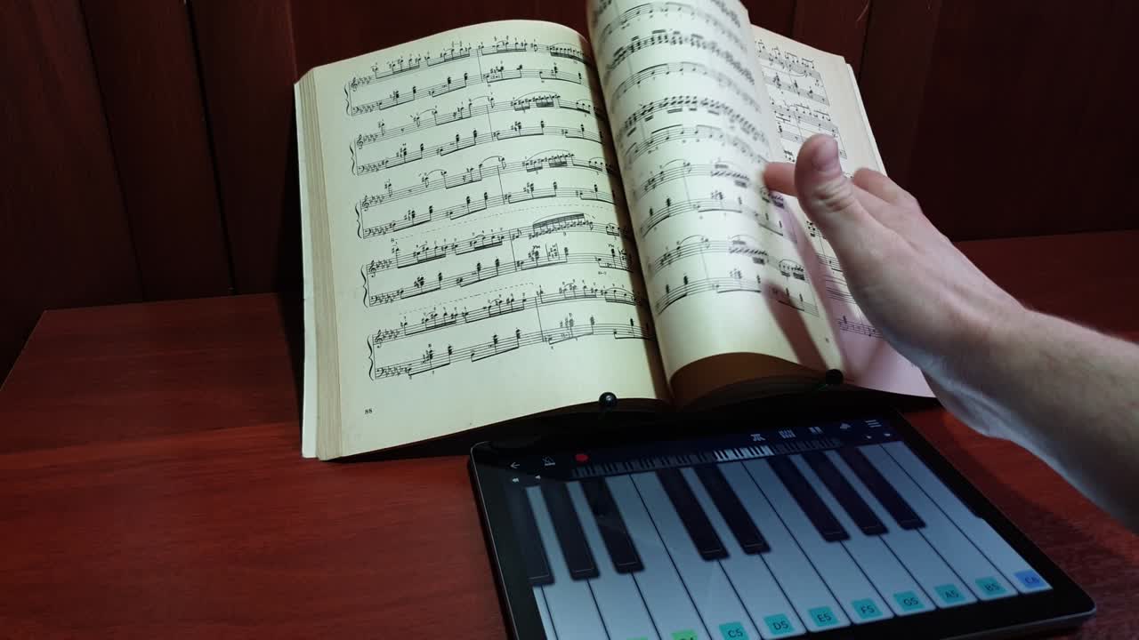 그 남자는 음으로 가상 피아노 키보드를 연주합니다.