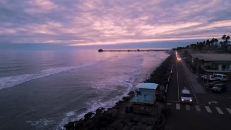 drone view of the oceanside pier with a pink sunset