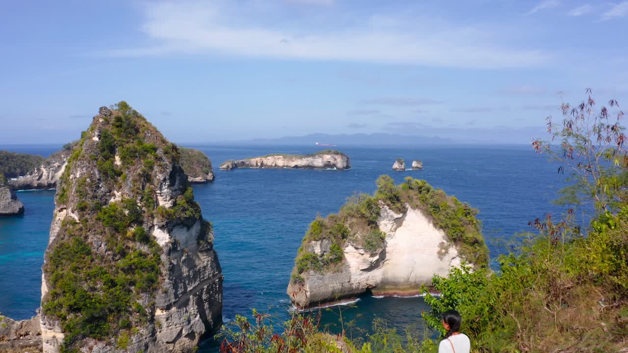 Establishing shot of young girl standing on clifftop