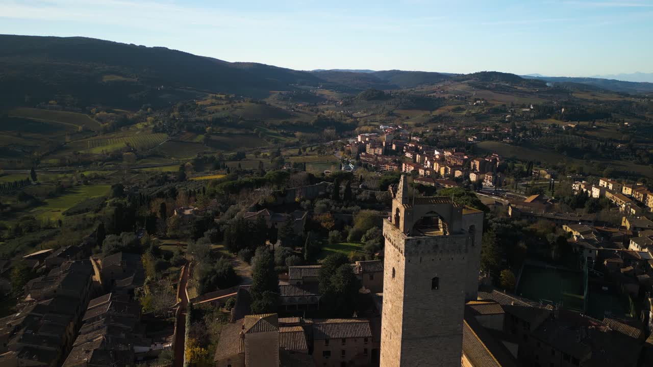 el avión no tripulado asciende por encima de la torre medieval en san gimignano para revelar el paisaje toscano