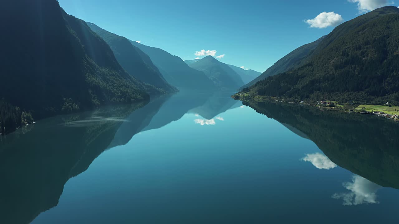 숲으로 인 산기?? 에 둘러싸인 노르웨이의 피어랜드 피오르드 (fjaerland fjord) 를 빠르게 날아다니며, 피오르드의 여전히 거울 같은 표면에 반사되는  은 구름.