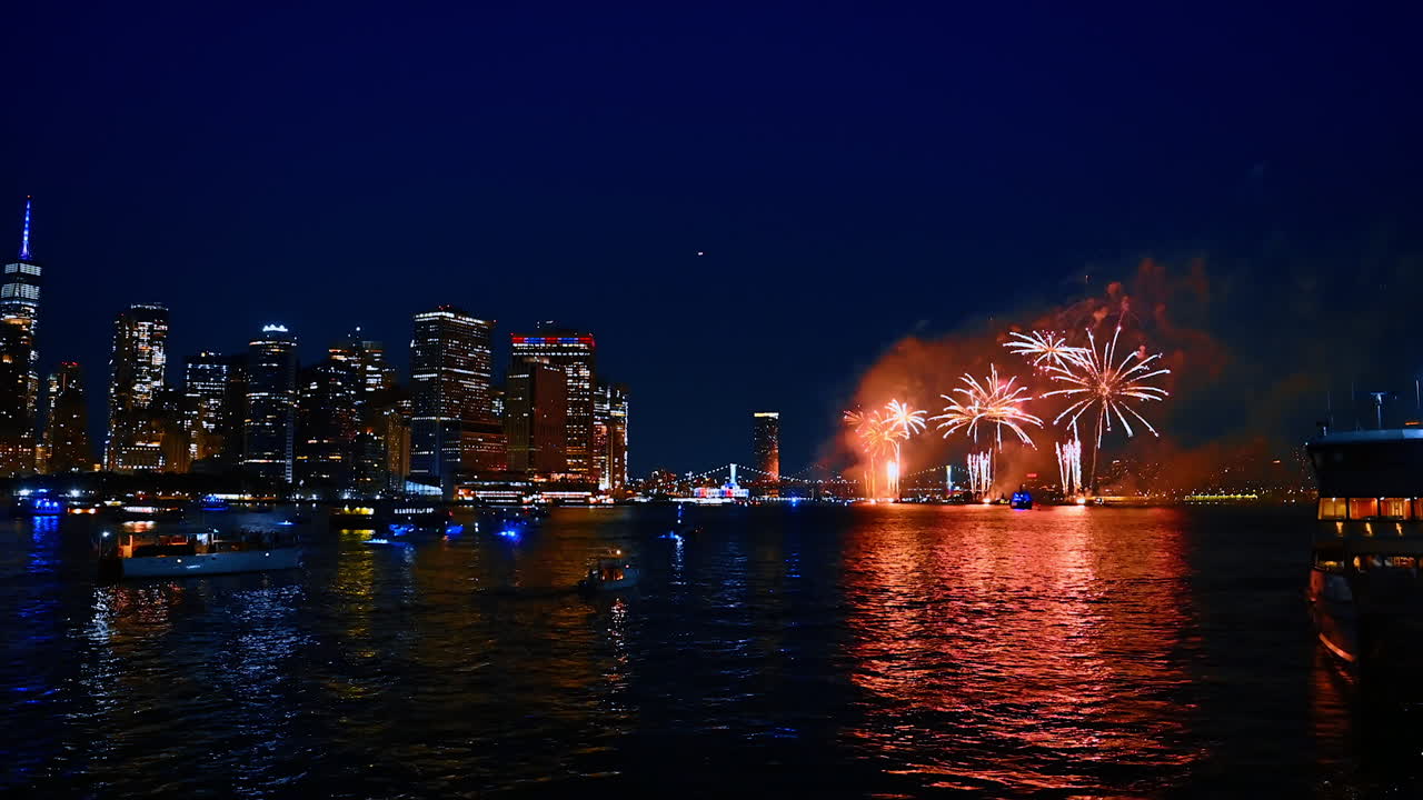 Celebration with stunning fireworks in modern New York, USA. View on the city skyline and fantastic show from the river at night