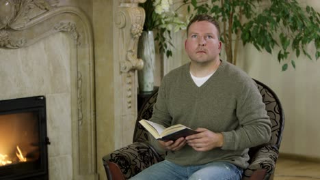 man reading by fireplace