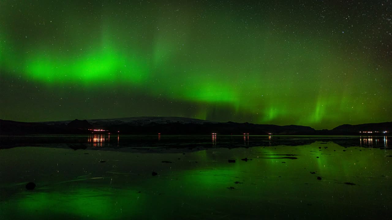sorprendente aurora boreal sobre un lago tranquilo en islandia - lapso de tiempo