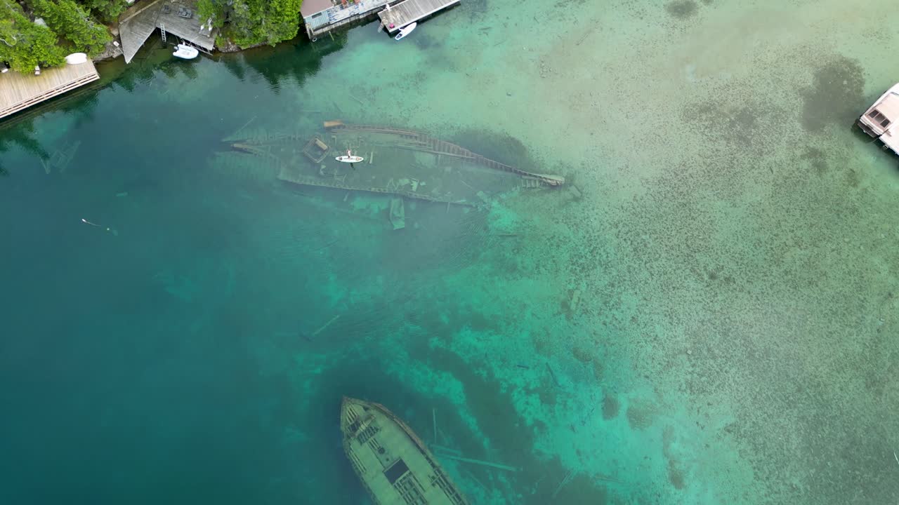 Aerial View of Sunken Shipwrecks in Clear Turquoise Water with Paddleboarder