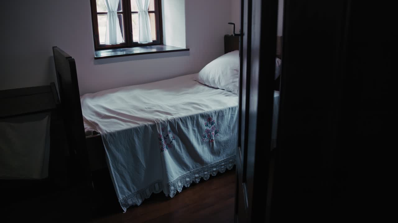 Simple traditional bed with embroidered linens in Kumrovec, Croatia
