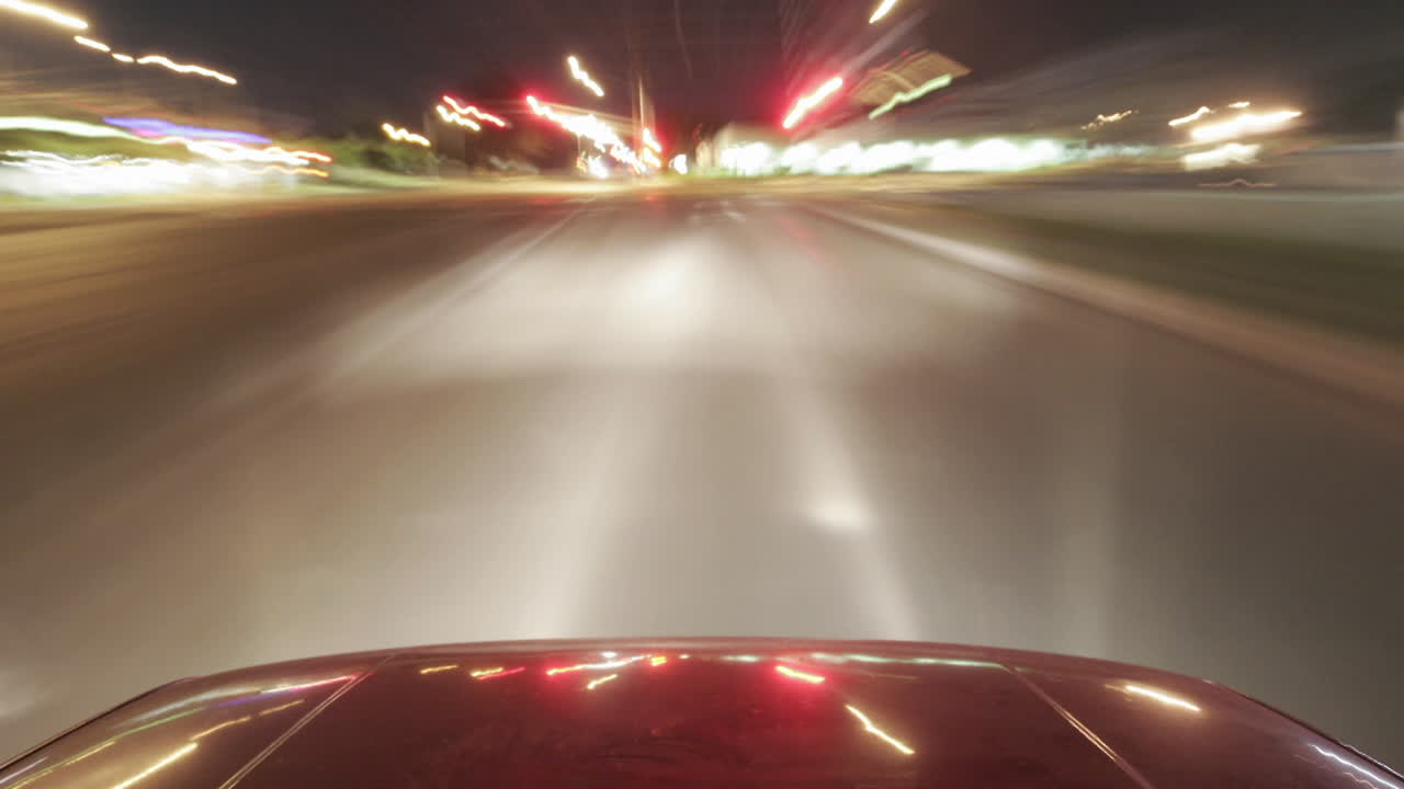 un coche brillante viaja por las calles de la ciudad por la noche