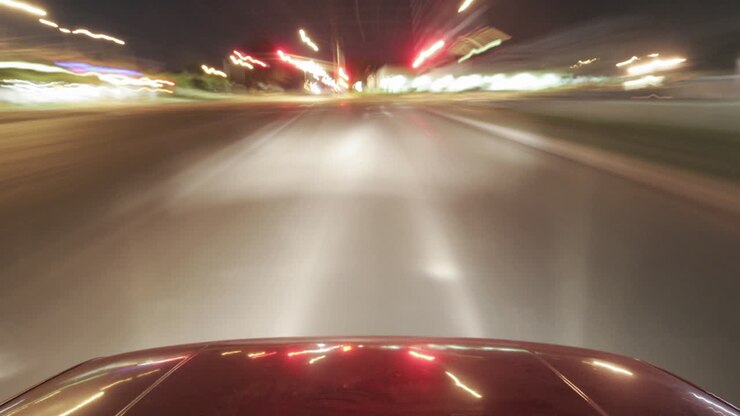 Un'auto lucida viaggia per le strade della città di notte.