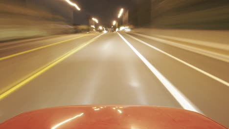 A-shiny-car-travels-on-city-streets-at-night