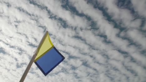 standard flags waving against cloudy blue sky on a sunny day