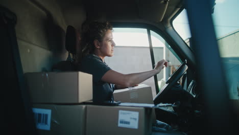female courier organizing packages in a delivery van