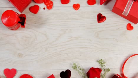 Red-roses,-gift-boxes-and-heart-shape-of-confetti-on-wooden-surface-4k