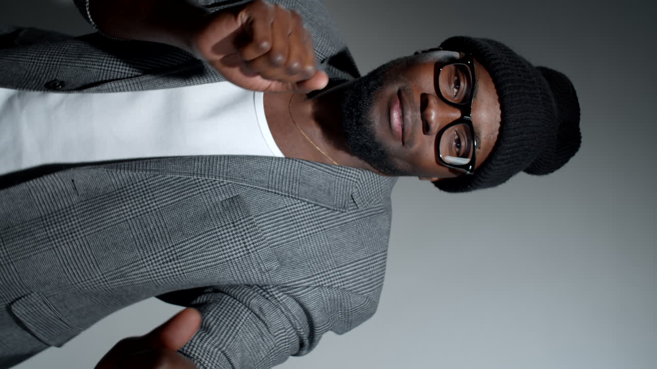 hombre negro hipster sonriendo y bailando en el estudio