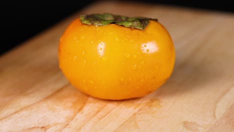 hands preparing to peel a ripe persimmon