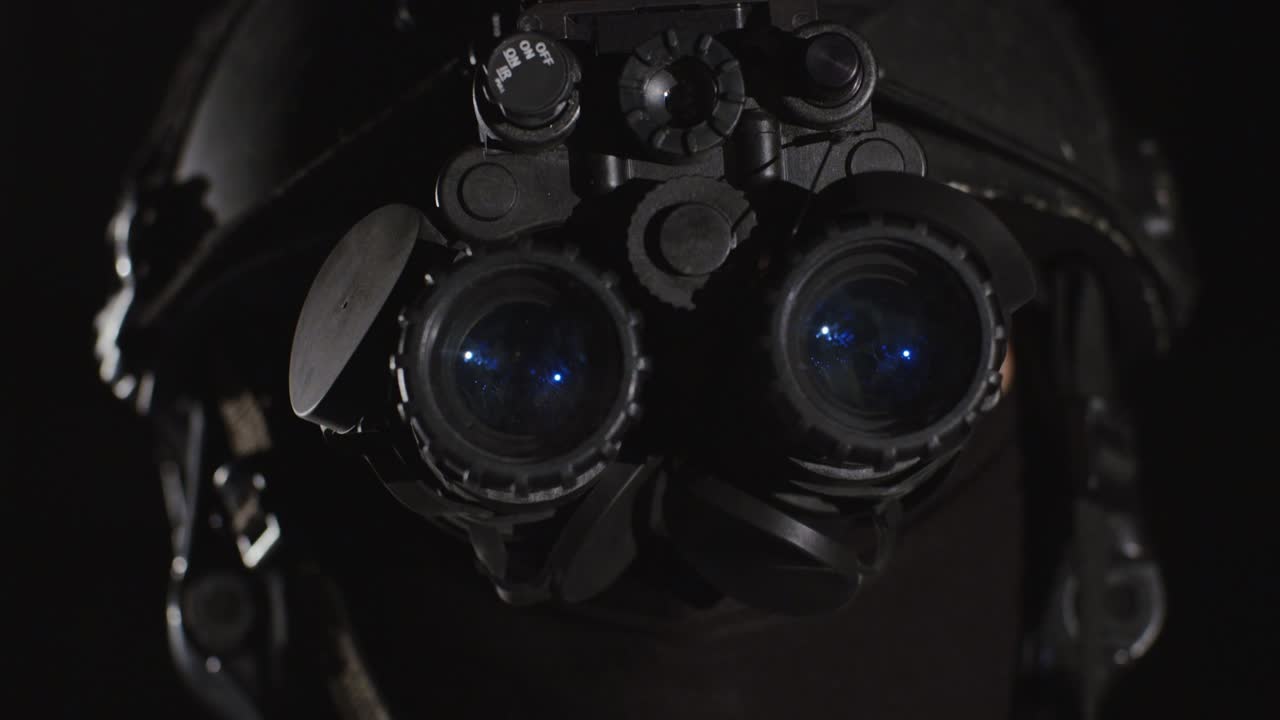 Closeup of special forces trooper using advanced night vision binocular optics