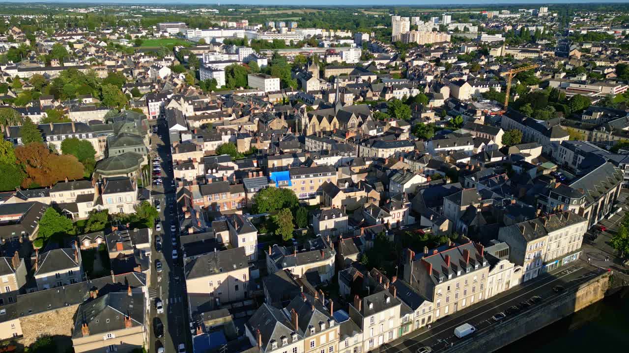 Riprese aeree sopra Laval che mostrano il fiume Mayenne, la chiesa di Saint-Vénérand, la via principale e gli edifici della città alla luce del sole