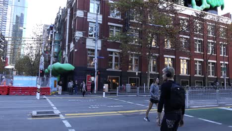 pedestrians crossing street near red brick building