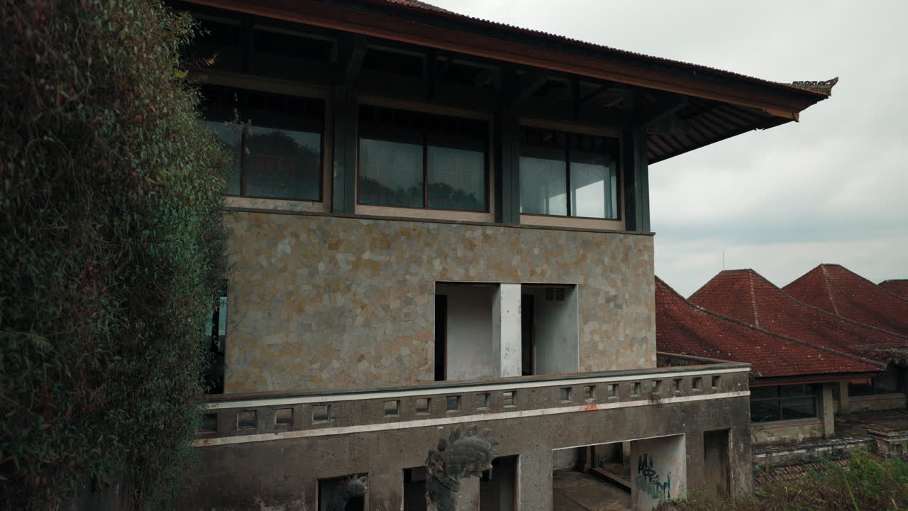Abandoned and Overgrown Building with Traditional Roof Tiles