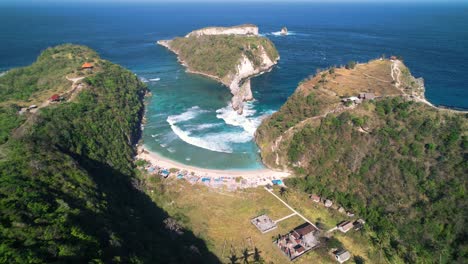 atuh beach hidden in limestone mount formations in nusa penida, bali, indonesia - aerial high angle reveal