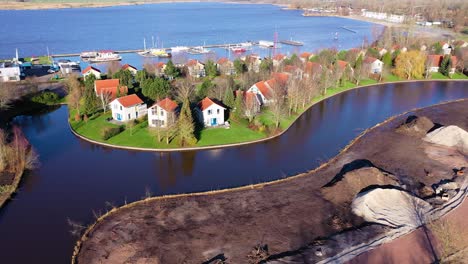 Retreat-Shot-of-Dutch-Holiday-Homes-on-Small-Island-near-Lake,-Steendam