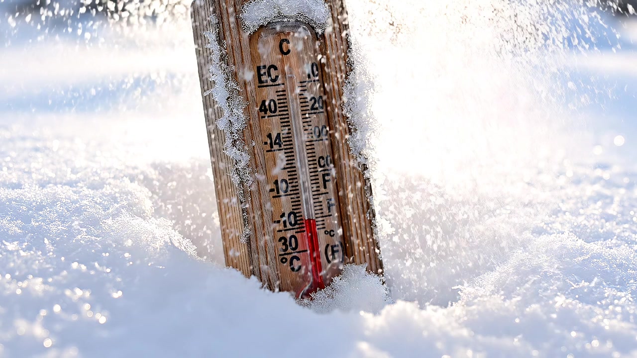 Outdoor thermometer in deep snow during a freezing winter day