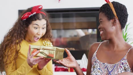 happy diverse female friends opening christmas presents