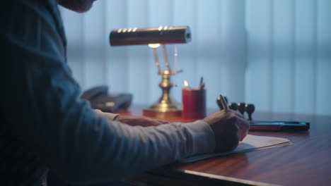 man signing documents in office