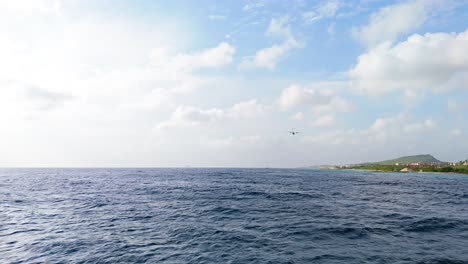 coastguard dash 8 plane flying low overhead above deep blue caribbean ocean off coast of curacao