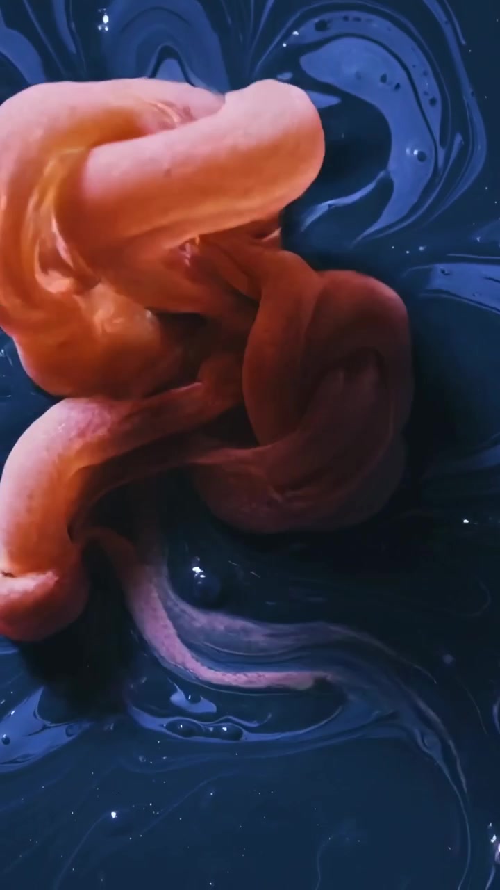 Vertical video: Appearing top pink foam looping shrinking shedding blob leaving navy vortex in tray